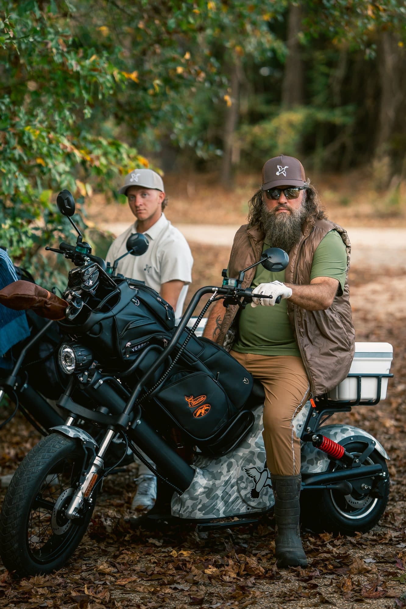 Duck-camo custom-wrapped EA Golf Bike built for Willie Robertson, with a rider seated on it in the woods