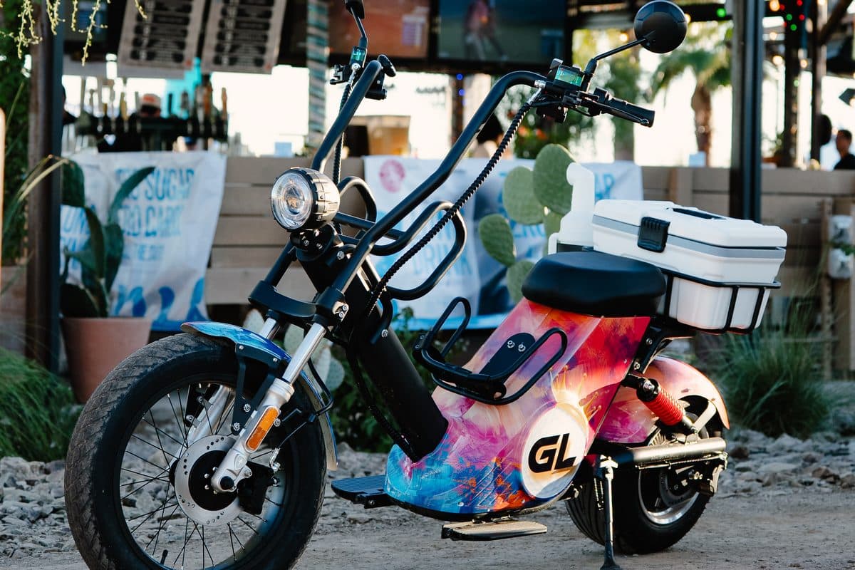 EA Golf Bike in a multicolor Grass League wrap with GL logo and white cooler outside an outdoor bar