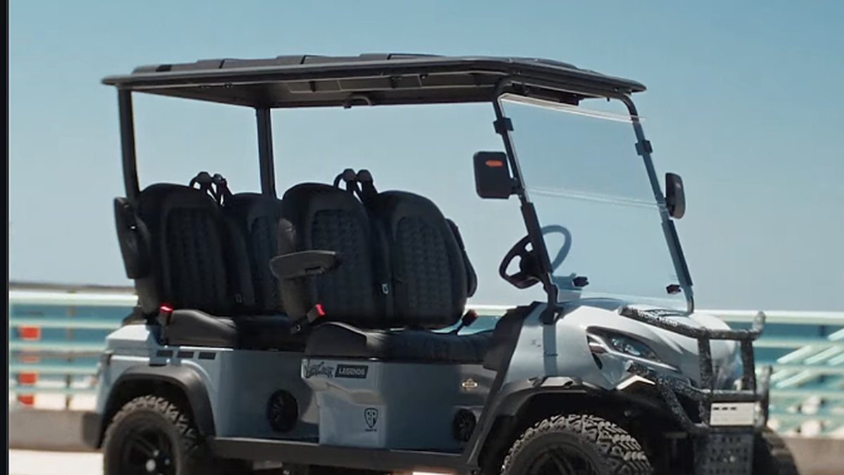 Custom EA Carts golf cart from the Legends and West Coast Customs collaboration parked on a waterfront pier