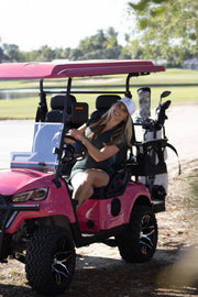 Woman driving a EA4R+ pink golf cart on a golf course